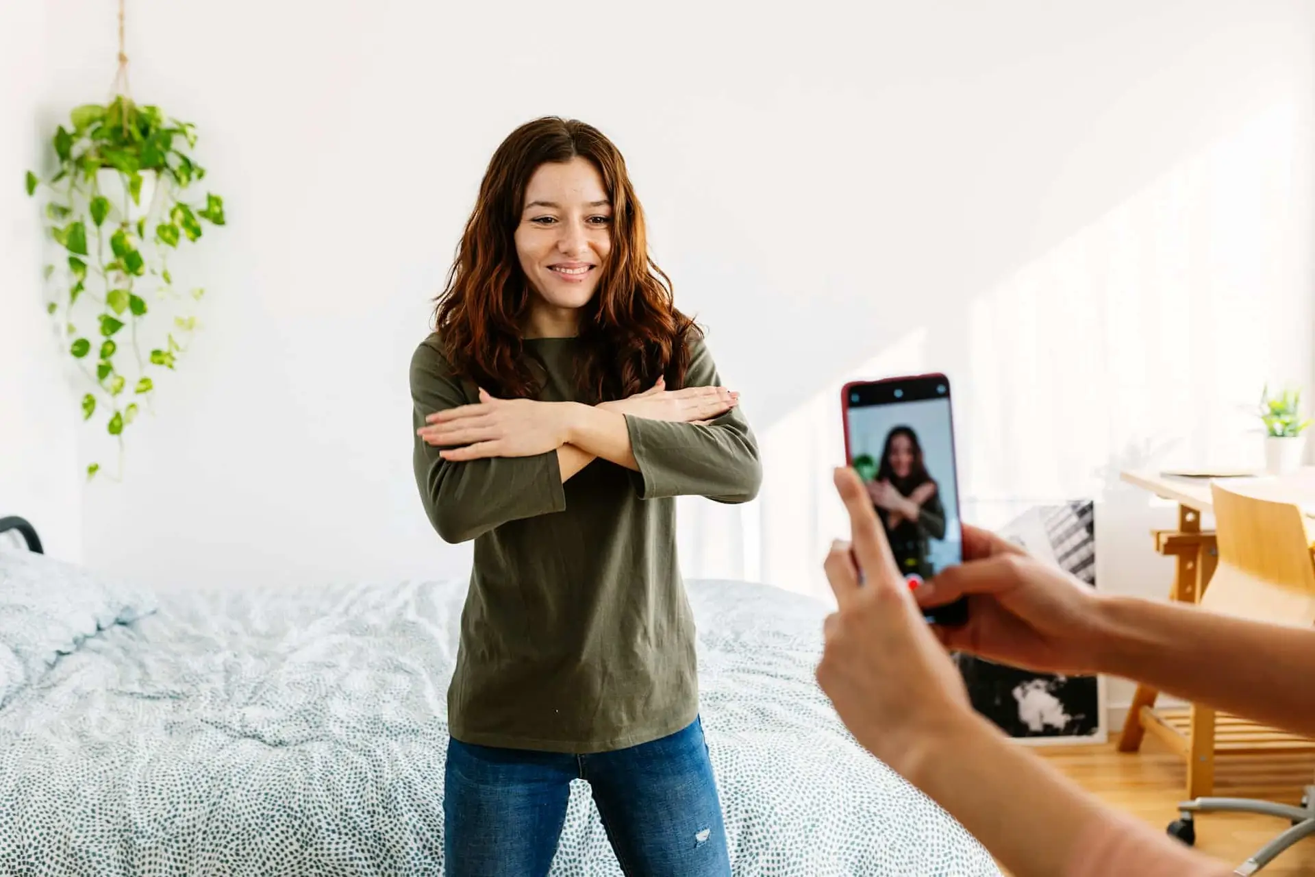 Young beautiful girl recording dance tutorial with mobile phone at home.